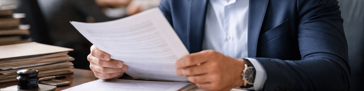 transcrição de imóveis em matrícula Funcionário de cartório analisa atentamente um documento em um ambiente institucional, com iluminação suave e natural