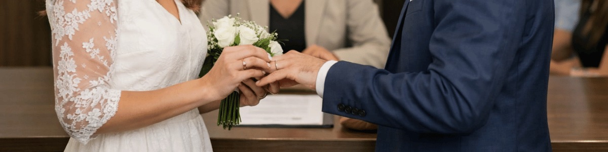 quanto custa casar no civil Casal realizando casamento civil em cartório durante cerimônia oficial, com troca de alianças em ambiente institucional elegante e iluminação natural suave.