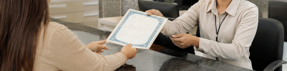 qual o valor de uma certidão de óbito Imagem realista de uma pessoa recebendo uma certidão em um cartório, com atendente sorridente entregando o documento em um balcão institucional.