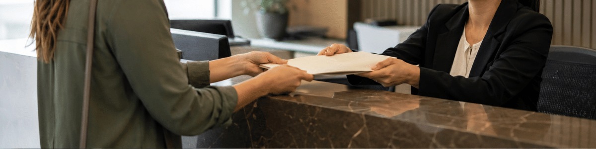 Pessoa entrega documentos a uma funcionária de cartório em um ambiente moderno e profissional, com iluminação suave e clima institucional.